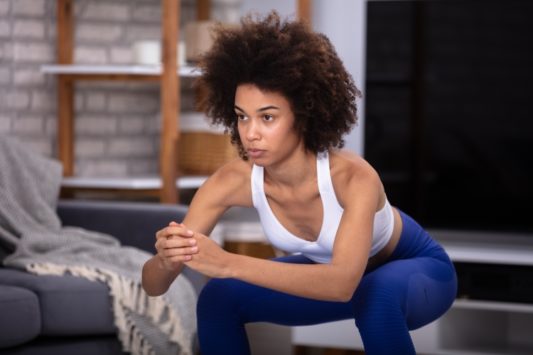 young woman performing full body workout at home